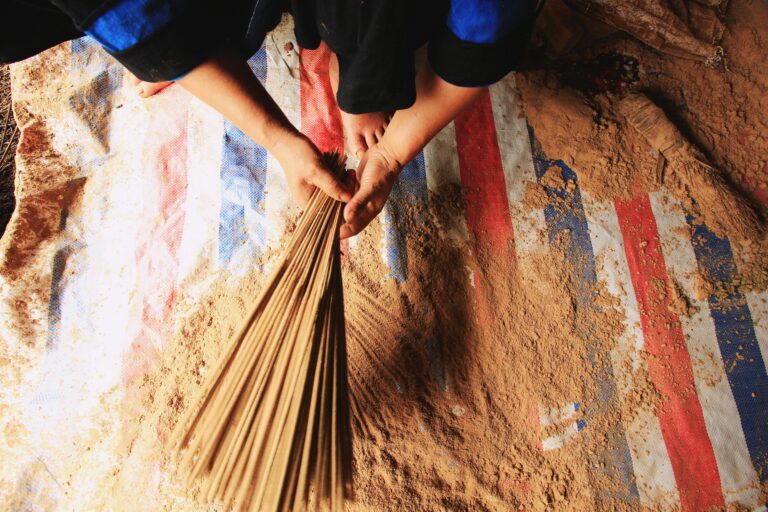 Close-up of hands bundling incense sticks in Cao Bằng, Vietnam.